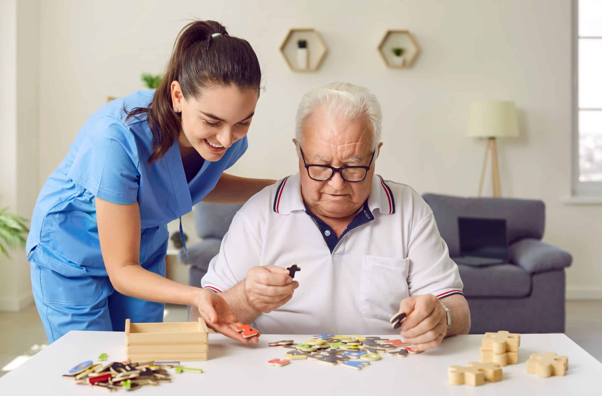 Eine Pflegerin puzzelt mit einem älteren Herr