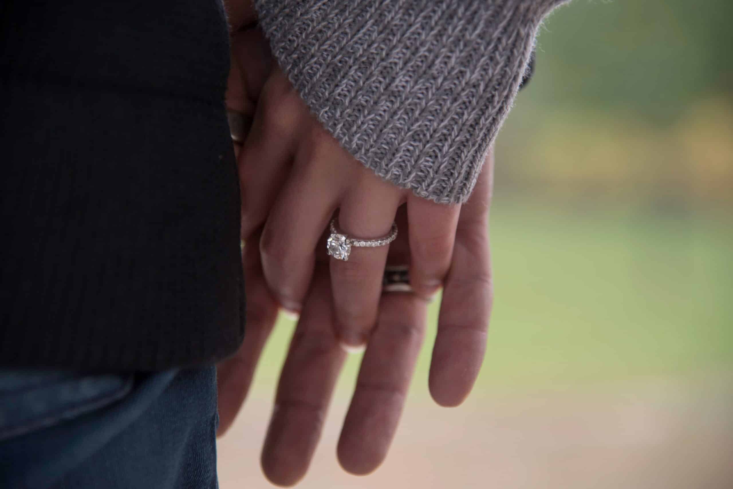 Verlobungsringe Silber an Hand eines Paares als Symbol für Liebe und bleibenden Glanz