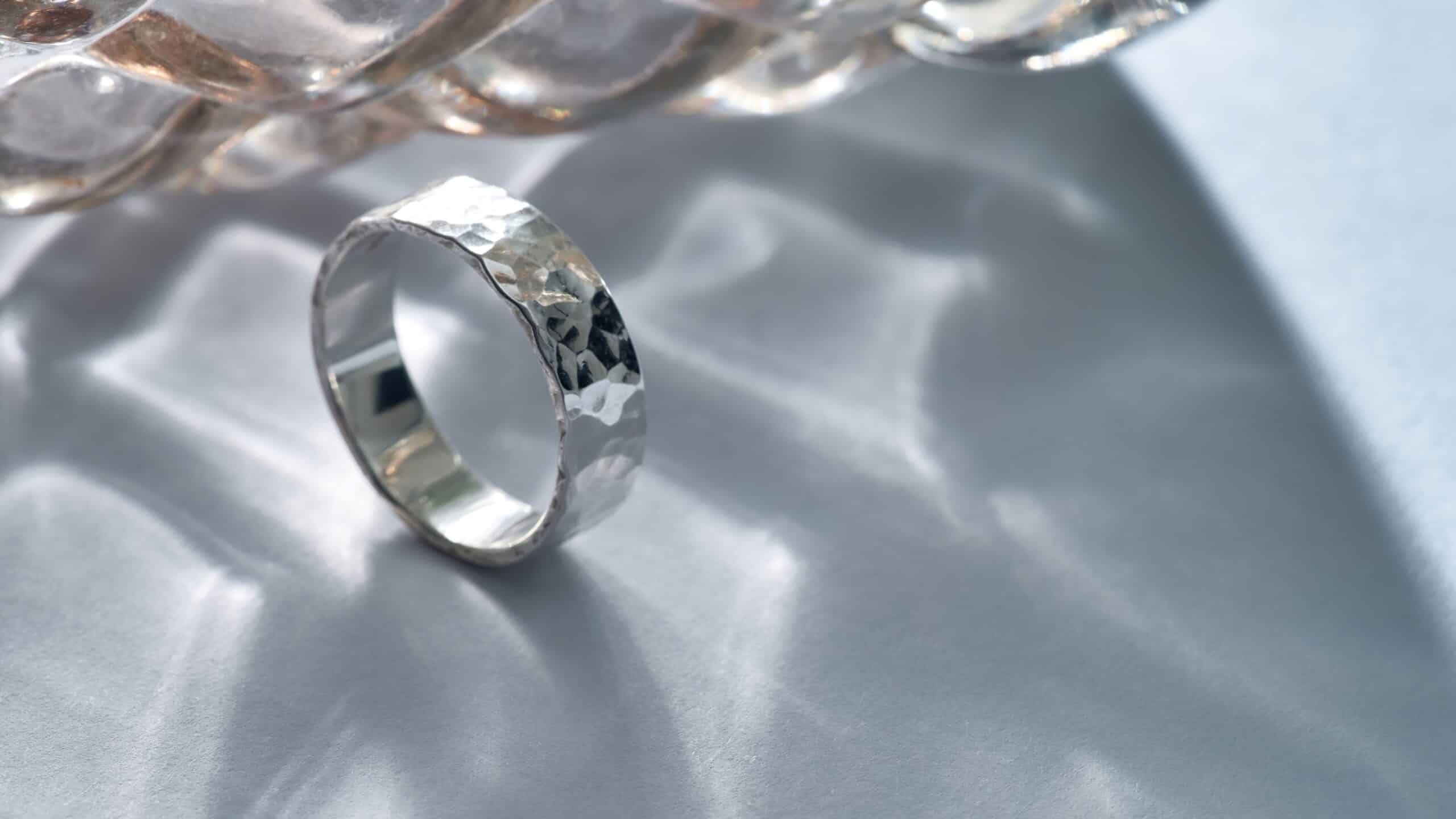 Verlobungsring Silber mit elegantem Hammerschlag Design auf heller Oberfläche